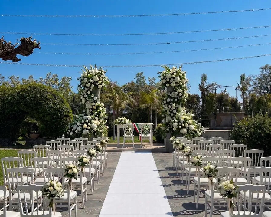 Casa Modò, Riposto A ceremony set up at Casa Modò, Riposto, white roses on the arch and the registrar's table beyond